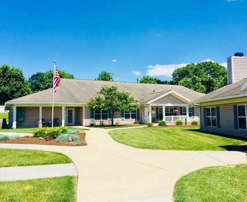 Exterior view of Linden Village with a flag and garden