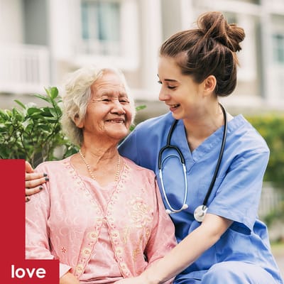 Caregiver smiling with a senior resident outdoors