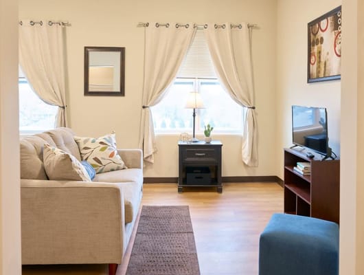 Warm and inviting living room with a sofa, lamp, and TV.
