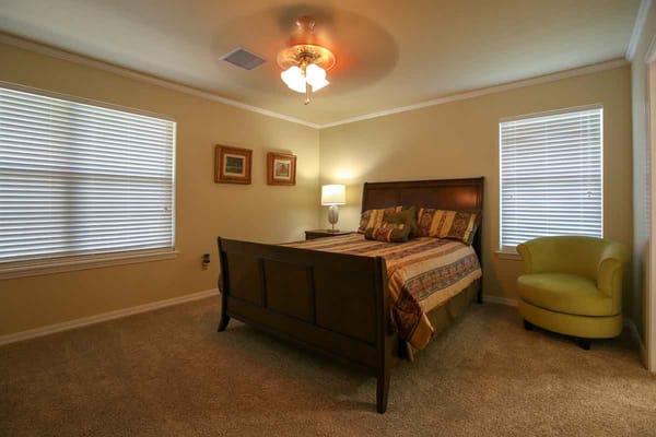 Comfortable bedroom with bed, lamp, and armchair