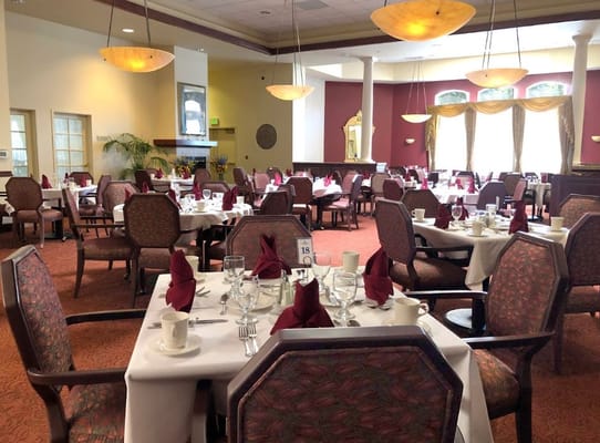 Elegant dining room set for service with tables and chairs.
