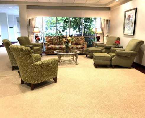 Cozy lounge with floral sofas and green chairs.