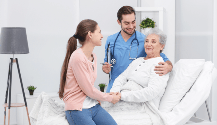 A caregiver interacting with a resident and a family member