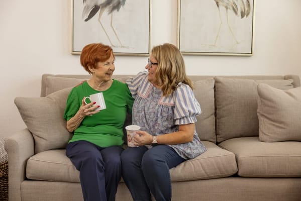Two women enjoying coffee in a cozy common area