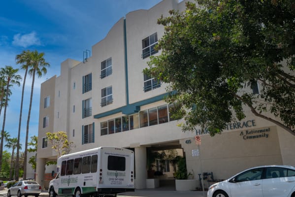 Exterior view of Harbor Terrace Retirement Community with a facility shuttle