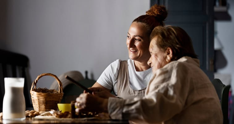 A caregiver and resident sharing a moment with food