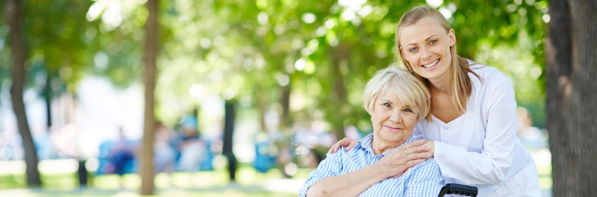 A caregiver with a resident in a sunny outdoor space