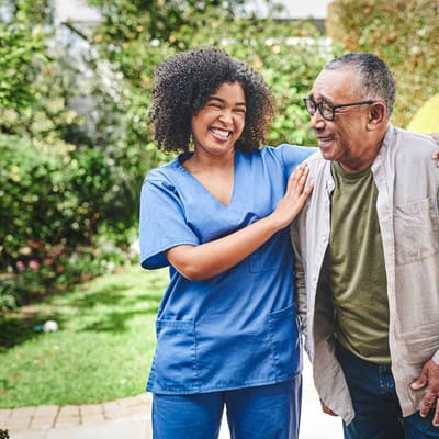 Staff member and resident laughing in a garden