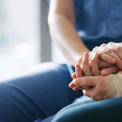 A caregiver holding hands with a resident