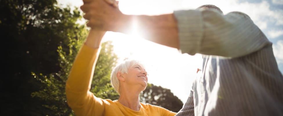 A couple dancing outdoors under sunlight