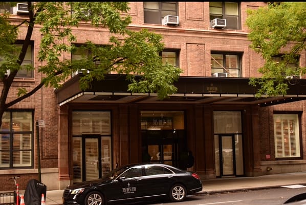 Exterior view of a senior living facility with a car