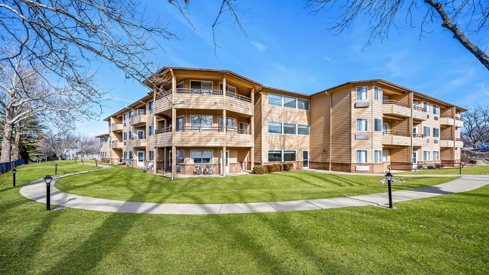 Exterior view of a senior living facility with landscaped lawn
