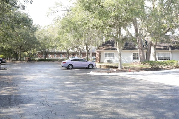 Parking area with trees and residential buildings in the background