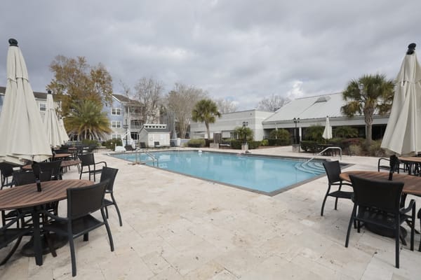 Outdoor pool area with seating and umbrellas