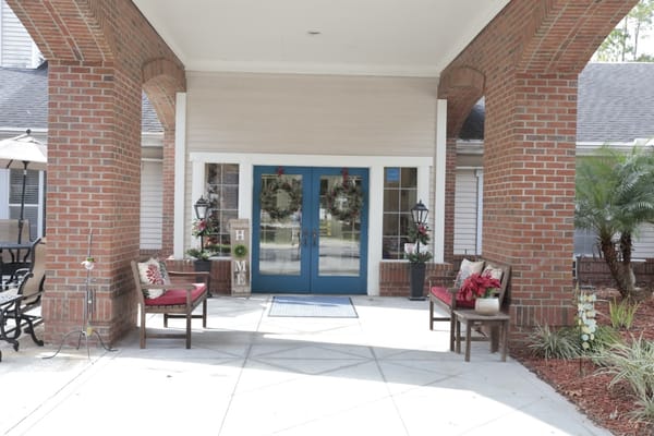 Covered entrance of a senior living facility decorated for the season