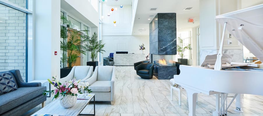 Bright, modern lobby area with piano and seating