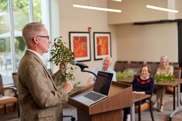A speaker presenting to engaged residents in a common area