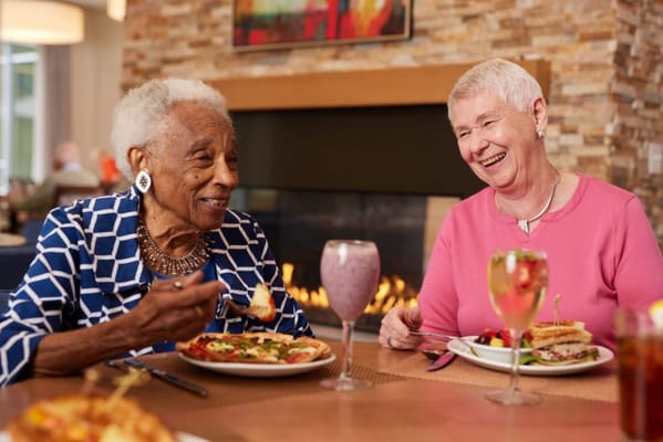 Two residents enjoying a meal together in a dining area
