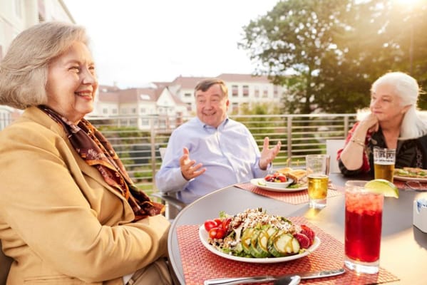 Residents enjoying meals outdoors in a social setting
