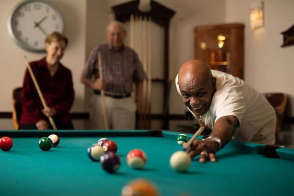 Residents enjoying a game of billiards in the activity room