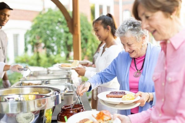 Residents enjoying a meal outdoors at a buffet