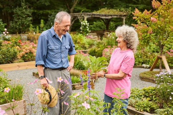 Seniors gardening together in a vibrant flower garden