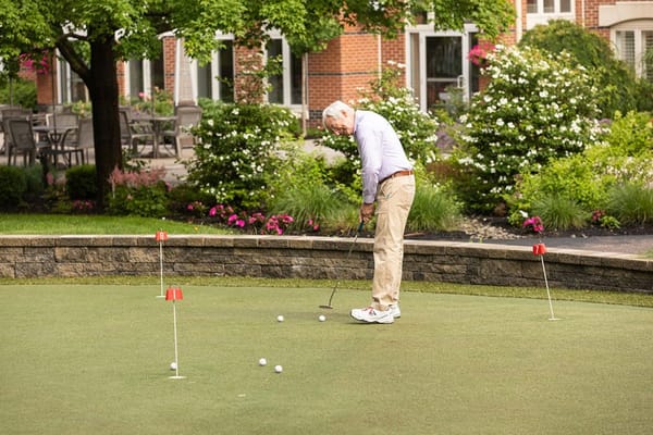 Resident practicing putting on a landscaped green