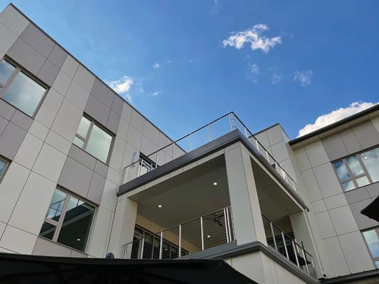 Exterior view of a building with a terrace and blue sky