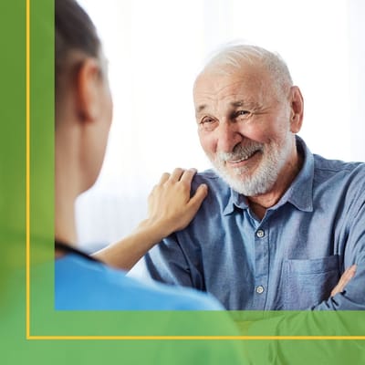 A caregiver interacting with a senior resident in a bright room