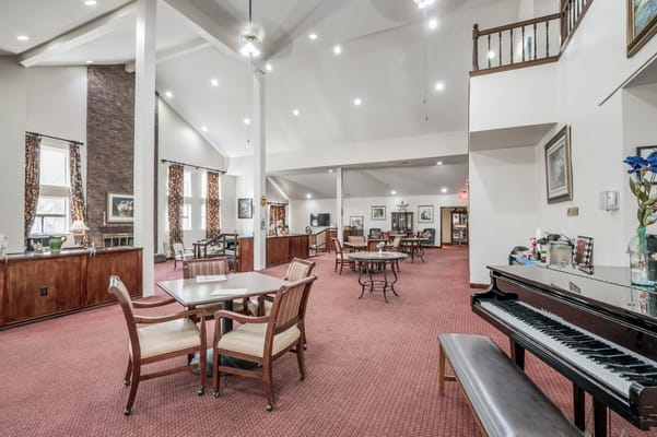 Interior view of a common area with tables and piano