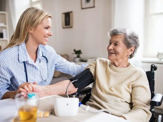 Nurse checking blood pressure of a smiling resident