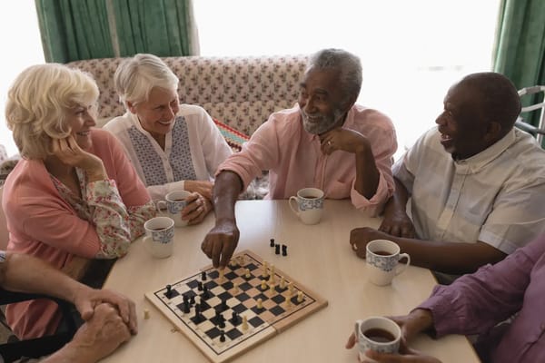 Residents enjoying a game of chess with cups of tea