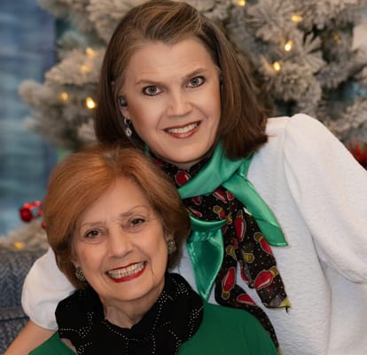 Two residents smiling in a festive common area setting