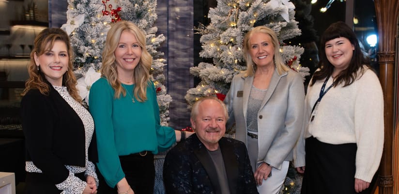 Five staff members posing in a decorated social space