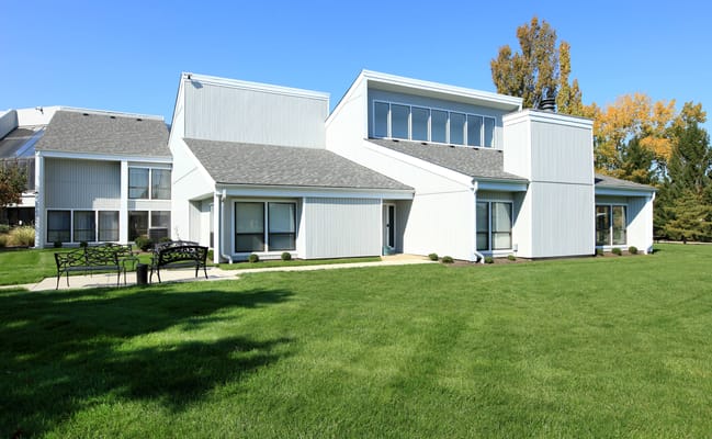 Exterior view of a senior living facility with green lawn