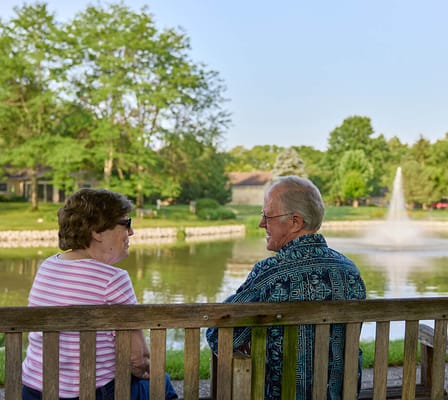 Two residents enjoying a serene moment by the pond