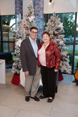 Residents posing for a photo by decorated Christmas trees