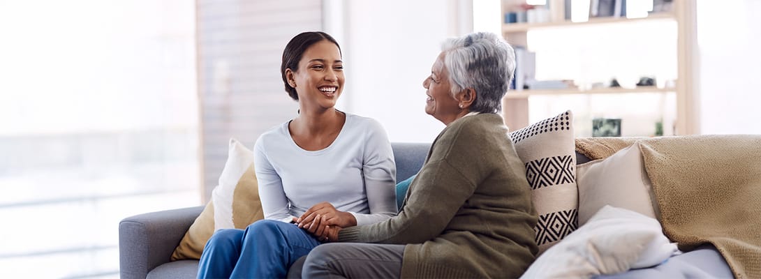 A caregiver and resident sharing a joyful moment in a cozy interior