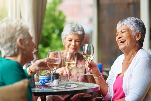 Residents enjoying a toast on a sunny patio