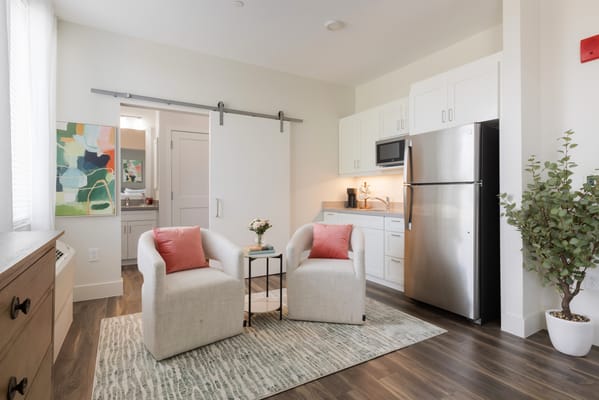 Bright, modern living space with kitchenette and seating area