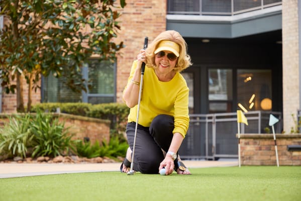 Resident playing mini-golf in a garden