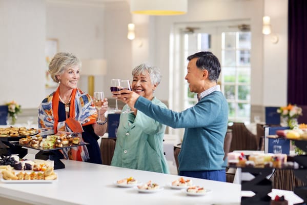 Residents enjoying a toast with food in a common area