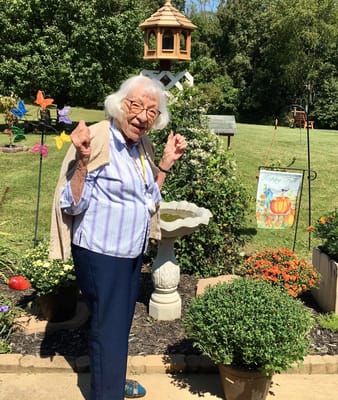 Resident enjoying the garden area with flowers