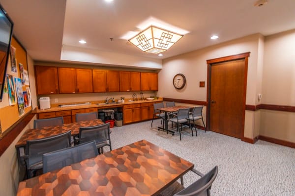 Common area with tables and kitchenette in a nursing home