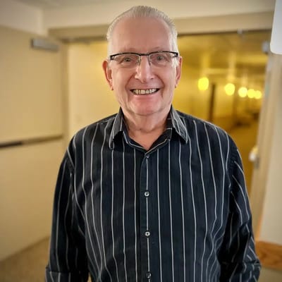 A resident smiling in a hallway.