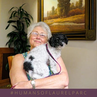 Resident holding a small dog in a common area