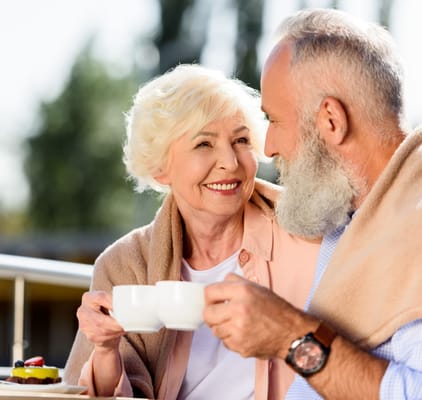 A woman and man enjoying coffee outdoors