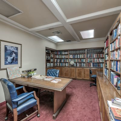 A cozy library with bookshelves and a desk