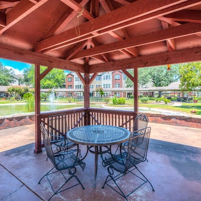 Outdoor gazebo with seating near a pond