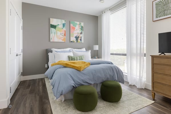 Brightly decorated resident room with bed and art
